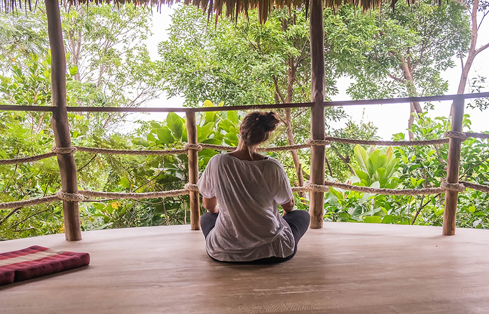 Annika Ziehen sitting in lotus pose overlooking the jungle