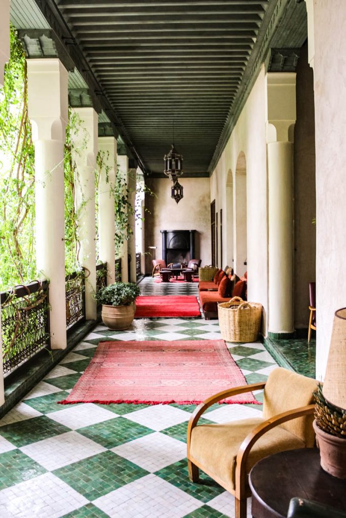 Open corridor with columns, green and white floor, and red carpets at El Fenn
