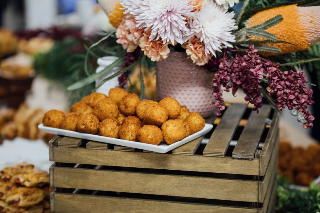 Platter of Bolinho on a wooden crate with vase of flowers