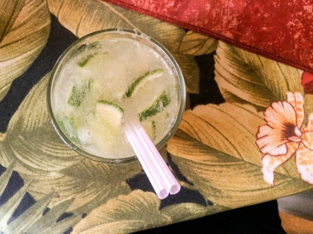 Caipirinhas with 2 straws on a printed tablecloth