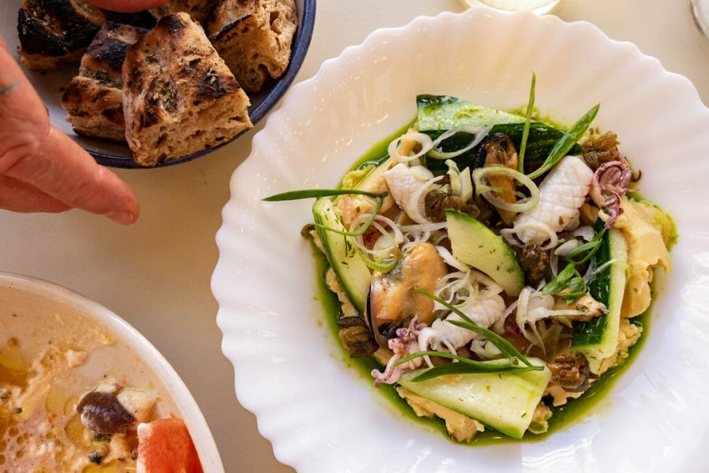 White plate with fava beans and seafood