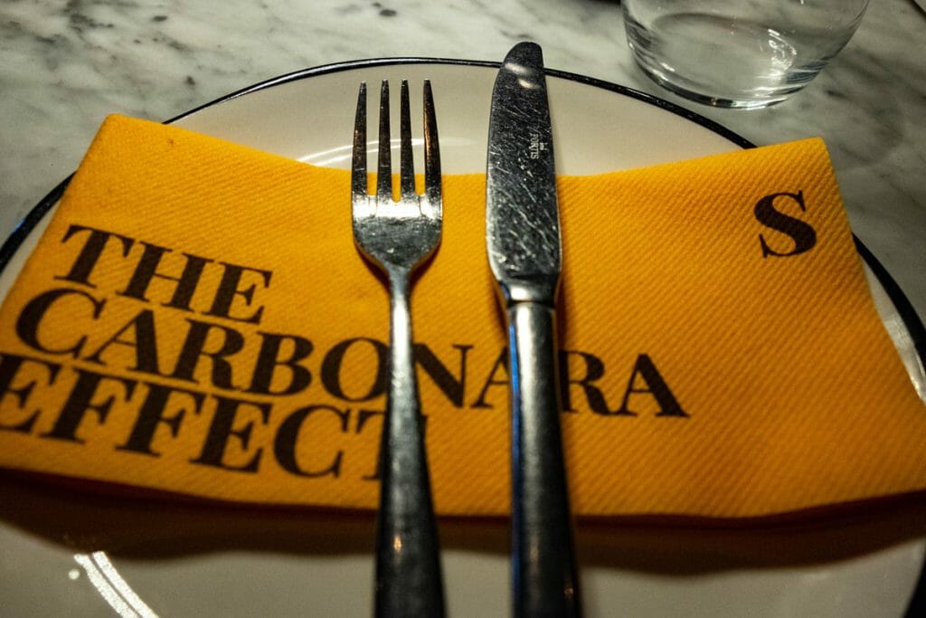 orange napkin on a plate with knife and fork
