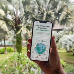 Hand holding phone with Sim Local eSIM app on screen